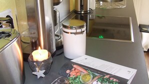 A kitchen counter with a lit candle, a white jar, a menu, and various food items. - Hochwald vacation apartment - in the heart of the Saarland (Quierschied)