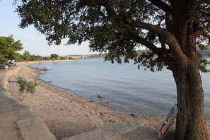 A riverbank with a tree, a bench, and a stone wall. - Villa in Starigrad near Paklenica National Park (Starigrad Paklenica)