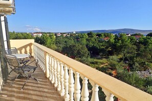 A balcony with a white balustrade, a table, and two chairs. - Villa in Starigrad near Paklenica National Park (Starigrad Paklenica)