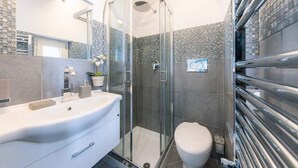 A modern bathroom with a glass-enclosed shower, a white sink, and a toilet. - Maika House - Amalfi Coast - seaview (Atrani)
