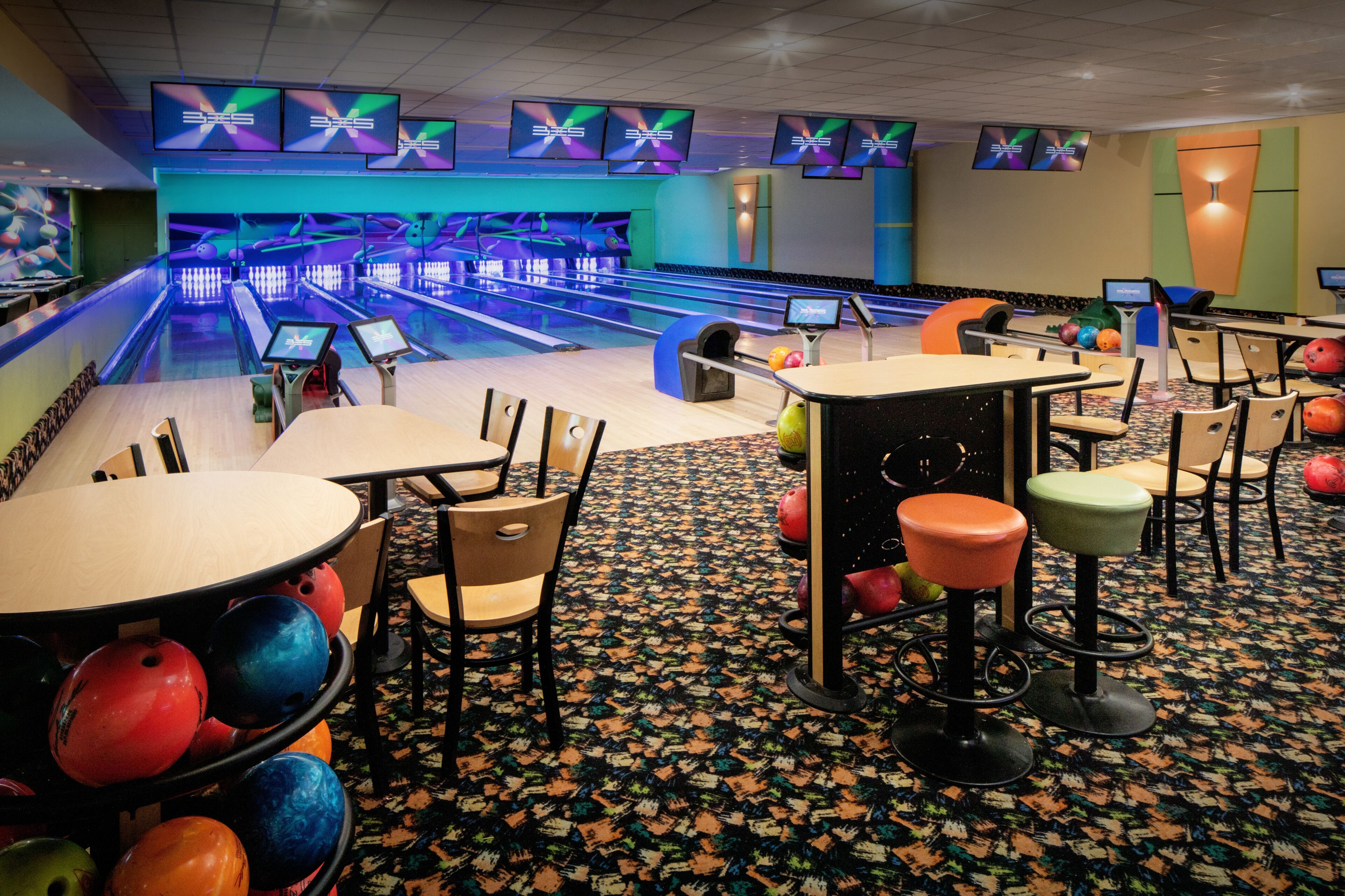 Un bowling doté de plusieurs pistes, de boules de bowling et d’espaces pour s’asseoir.