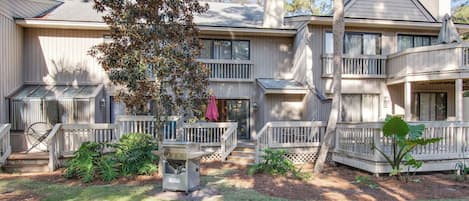 Stunning two-story home with a central entrance, balconies, and a charming porch area.