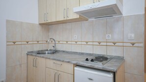 Una cocina con gabinetes color crema, un fregadero, una estufa y un lavavajillas.