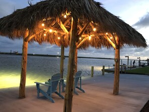 A wooden gazebo with a thatched roof and string lights, overlooking a body of water. - “Little Salt” GREAT LOCATION on intercoastal! Catch fish from backyard  (Bay city)