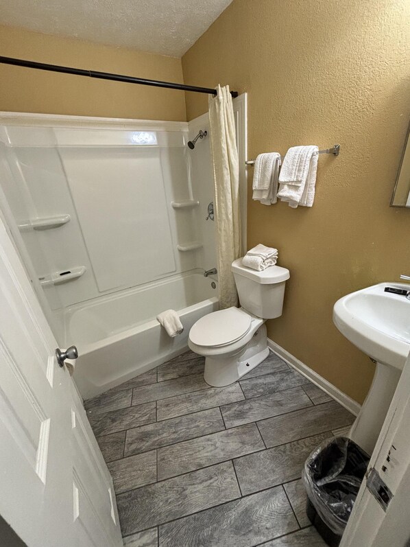 A bathroom with a bathtub, toilet, and sink.