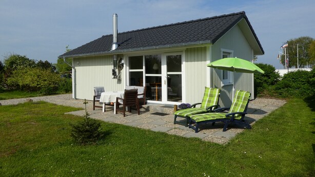 A small house with a patio, a table, two chairs, and two lounge chairs. - Small modern house in the countryside, close to the Schlei and the Baltic Sea (Kappeln)