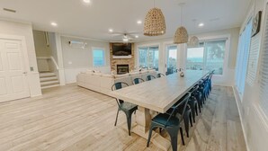 Une cuisine spacieuse avec une longue table à manger, des sièges intégrés et une cheminée.