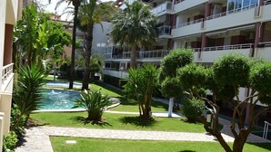 A courtyard with a swimming pool, palm trees, and a stone pathway. - Anacasa Dianium Ausias March AP1112 (Denia)