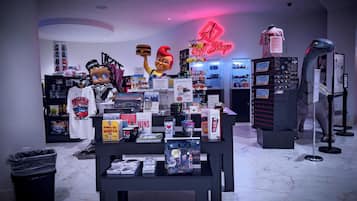 A gift shop with various merchandise displays, including books, toys, and a neon sign.