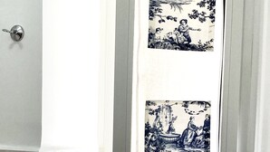 Una puerta con marco blanco y un panel de vidrio con grabados antiguos en blanco y negro.