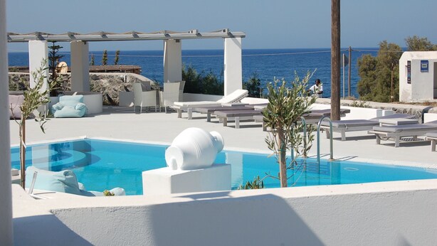 A pool area with lounge chairs and a pergola overlooking the sea. - Sea paradise villas (Santorini)