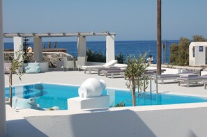 A pool area with lounge chairs and a pergola overlooking the sea. - Sea paradise villas (Santorini)