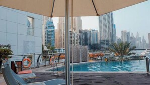 A rooftop pool with a city view, lounge chairs, and a lifebuoy. - Signature Hotel Dubai Marina (Gillingham)