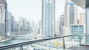 A high-rise building with a view of a river and other buildings. - Signature Hotel Dubai Marina (Gillingham)