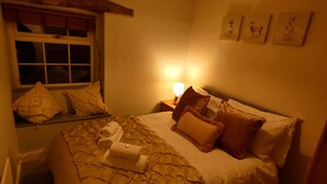 Un dormitorio con cama, almohadas, una ventana y decoración en la pared.