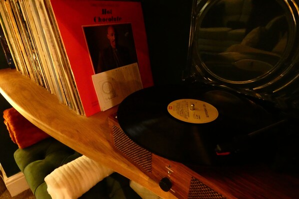 A record player with a vinyl record and a red book titled "Hot Chocolate" on a wooden surface.
