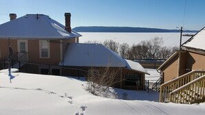 Ein Haus mit schneebedecktem Dach und Blick auf einen zugefrorenen See.