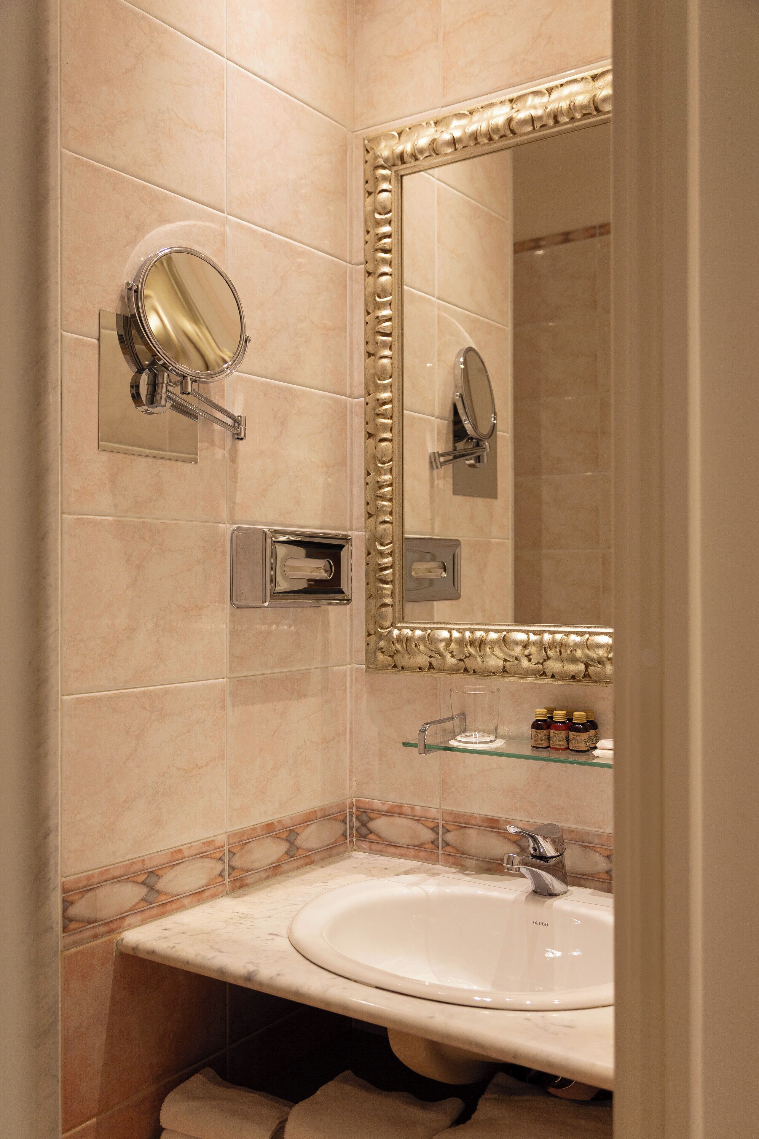 Un bagno con lavandino, specchio e articoli da toilette.