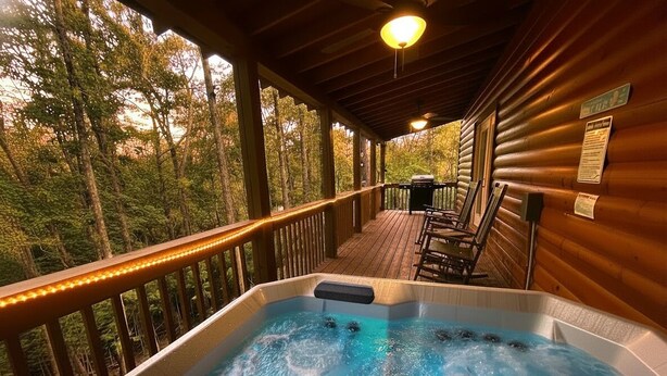 Ein Whirlpool auf einer Holzterrasse mit Blick auf Bäume.