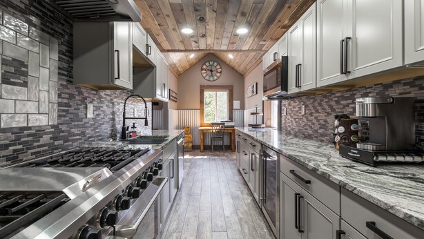 A modern kitchen with a central island, stainless steel appliances, and a wooden ceiling. - Pet Friendly Home! Cub House,3Br/2½Ba,Sleeps 8,Firepit,BBQ,Golf,20m 2 YNP (Island Park)