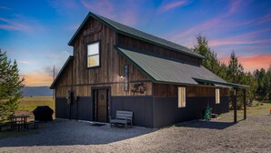 A rustic wooden cabin with a metal roof, a welcome sign, and a bench outside. - Pet Friendly Home! Cub House,3Br/2½Ba,Sleeps 8,Firepit,BBQ,Golf,20m 2 YNP (Island Park)