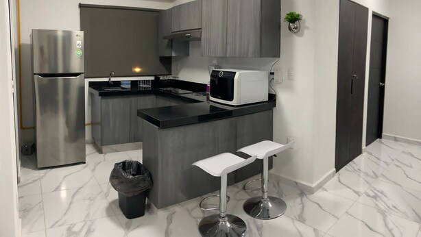 A modern kitchen with a built-in island, stainless steel appliances, and a marble floor. - Rent New Apartment in Acapulco 5 min. from the airport beach and La Isla. (Acapulco de Juárez)