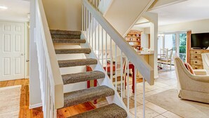 A staircase with stone steps and white railings leading to a dining area with a table and chairs.