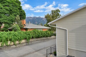 A residential street with houses, a clear sky, and mountains in the background.