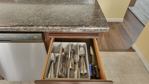 Un cajón de cocina con utensilios.