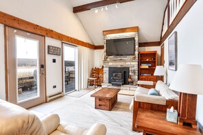 A spacious living room with a fireplace, a sofa set, a coffee table, and a television mounted above the fireplace. - Lakefront Cottage w Fireplace, Private Lake Access, Dock, Big Yard (Albrightsville)