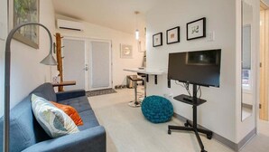 A living room with a sofa, a TV, a coffee table, and a chair. - #HabitueHomes - Green Spot Studio- Dog Friendly! (Boise)