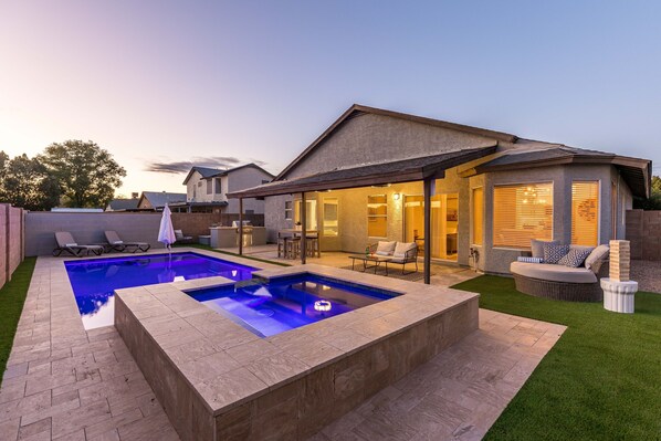 Enjoy a backyard with a rectangular pool, lawn, and patio seating.