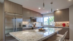 A modern kitchen with a large island, stainless steel appliances, and a view of the outdoors. - 1.5 Blocks From The Beach: The High Tide  in Del Mar (Del Mar)