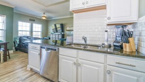A kitchen with white cabinets, a granite countertop, a dishwasher, a sink, and a blender. - Pathway to the Sea w/ OCEAN VIEWS! (Corpus Christi)