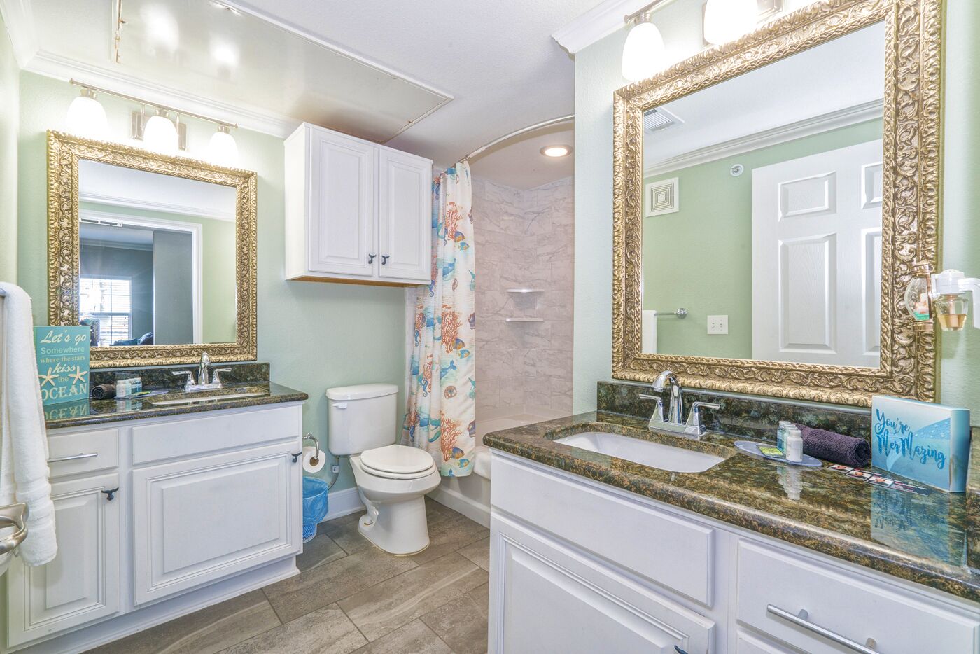 A bathroom with two sinks, a toilet, and a shower curtain.