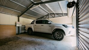 Valkoinen lava-auto oli pysäköity metalliseen autotalliin, ja oven päällä oli kyltti.