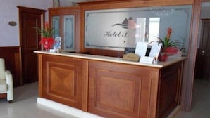 A reception desk with a sign that reads "Hotel B" and a framed picture above it. - Hotel Belvedere (Margherita di Savoia)
