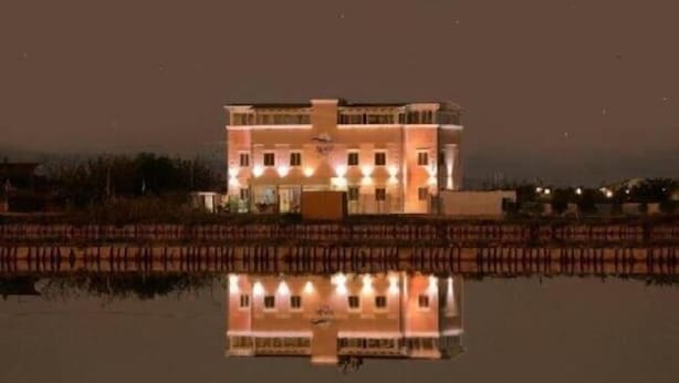 A building with a symmetrical facade, multiple windows, and a central entrance. - Hotel Belvedere (Margherita di Savoia)