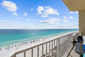 A balcony with a view of a beach and ocean.