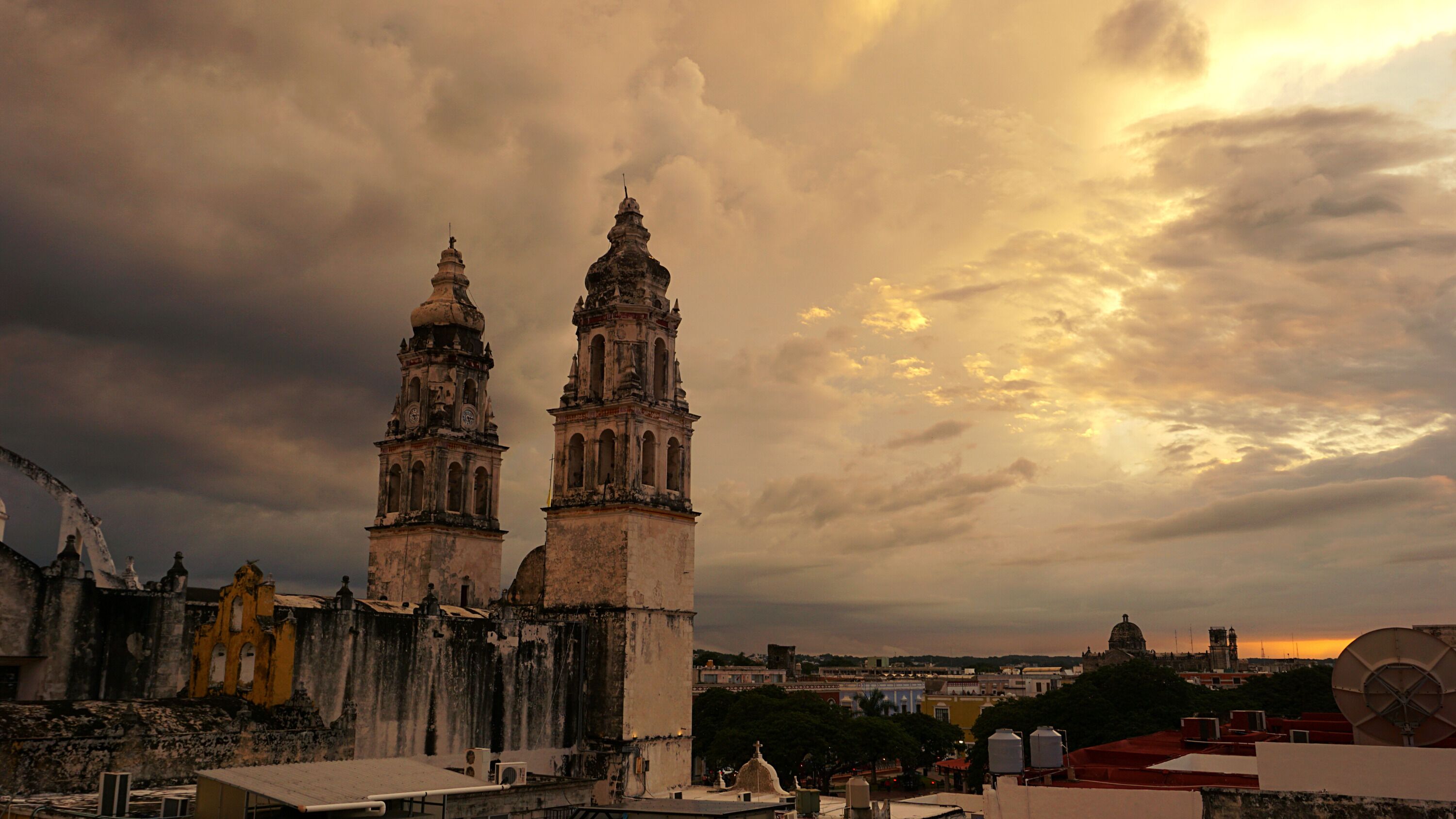 Un edificio histórico con dos torres destacadas y una cúpula, rodeado de otras construcciones.