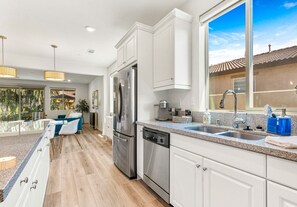 Enjoy cooking in this well-equipped kitchen with a large window offering a view of the surrounding landscape.