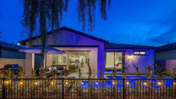 Uma casa moderna com piscina, área de estar externa e um pátio bem iluminado.