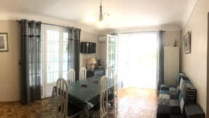 A dining area with a table, chairs, a lamp, and a TV. - VILLA 230 m² - 16 Pers - 8chambres -4000m² de parc /piscine 10 x 5m a 5 mn plage (Argelès-sur-Mer)