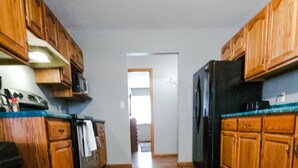Una cocina con armarios de madera, un refrigerador y una estufa.
