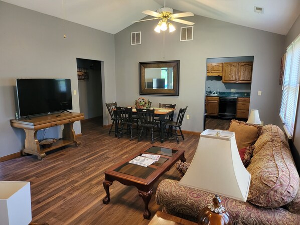 A living room with a TV, wooden coffee table, and patterned sofa. - 1500 Sq.ft. of Quaint Comfort in the heart of Olney close to downtown! (Olney)