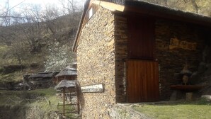 Un edificio de piedra con puerta de madera y un letrero.