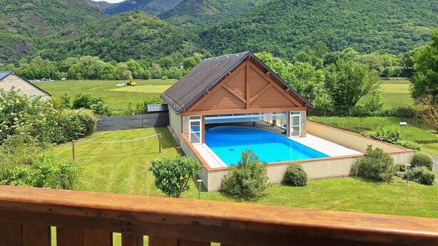 Una casa con piscina, rodeada de colinas y montañas verdes y exuberantes.