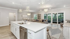 A spacious kitchen with a large island, stainless steel appliances, and pendant lighting. - Beautiful Villa in Lost Key | EV Charger | Screened Balcony | Private Beach Club | Pools | Free Golf (Pensacola)