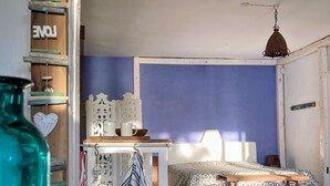 Een slaapkamer met een bed, een tafel en een hanglamp.