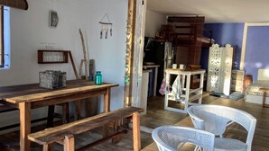 Een rustieke kamer met een houten tafel, een bank en rieten stoelen.